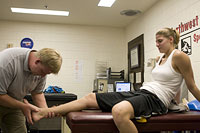 Athletic trainer checks out an ankle