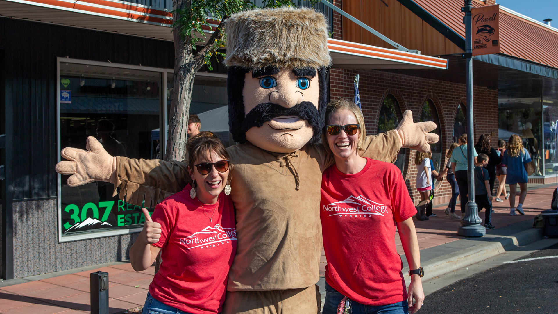 Two Northwest College employees with the Trapper mascot