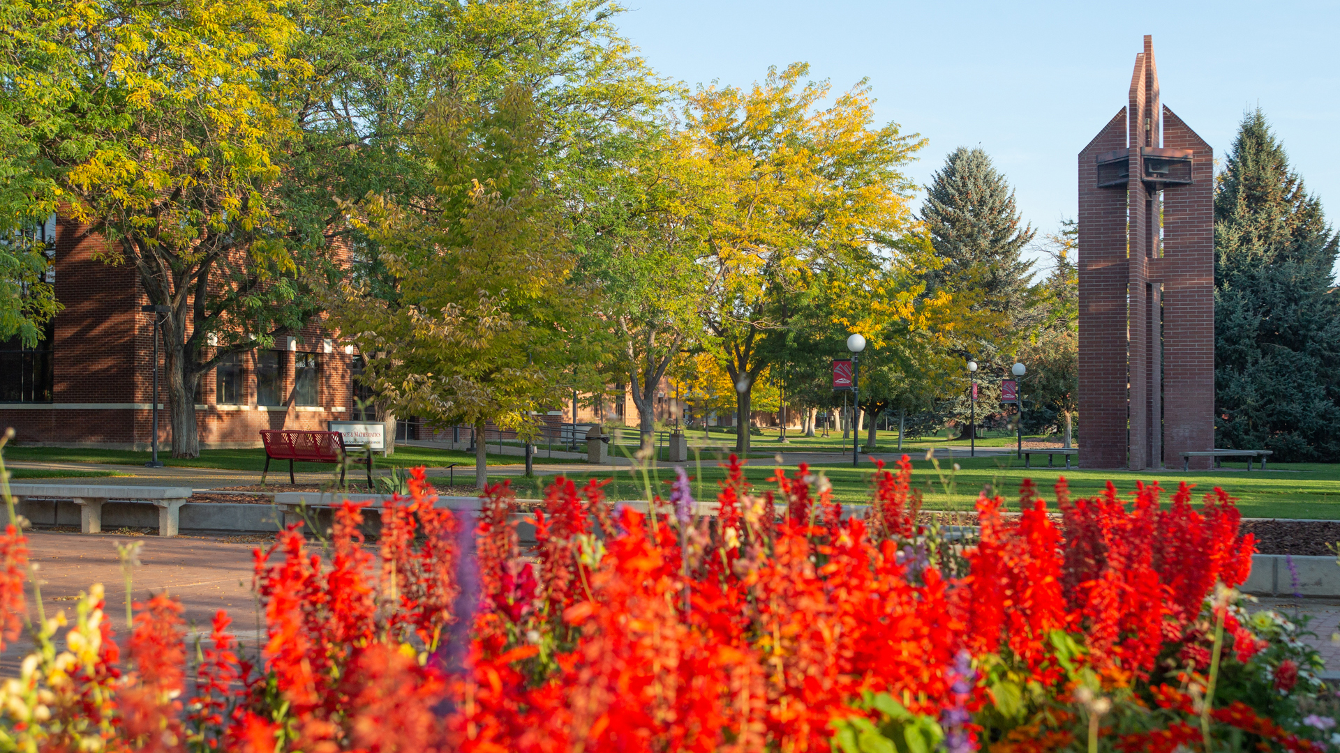 Carillon in campus mall with bright red flowers in foreground