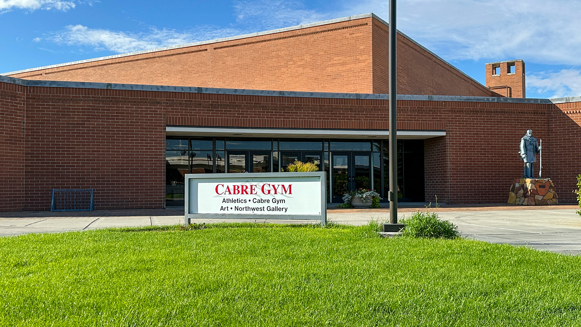 Outside of Cabre Building with a blue sky and green grass