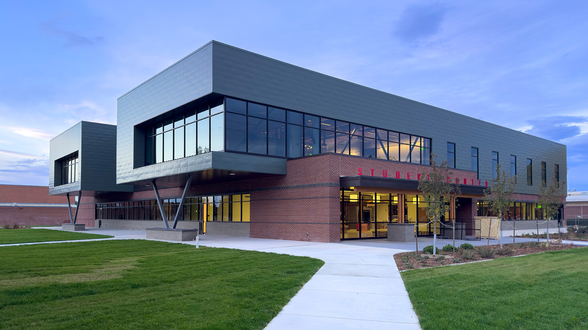 Northeast facing view of the student center at sunset with low light reflecting off second story windows and partly cloudy ble sky