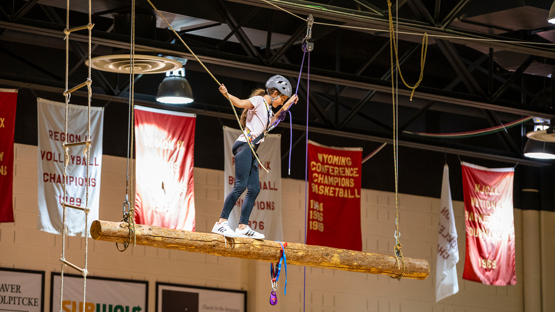 Female student balancing on a hanging log