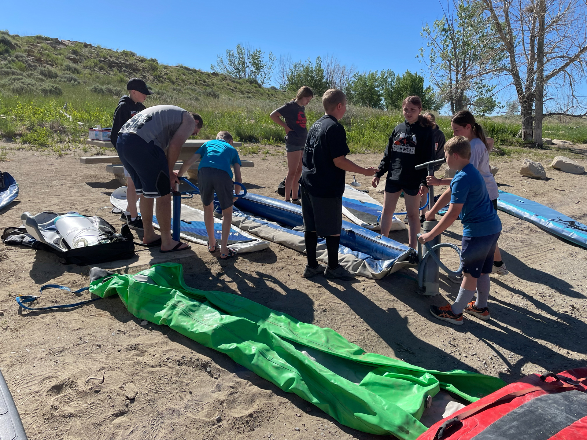 Kids preparing boats on a lakeside beach